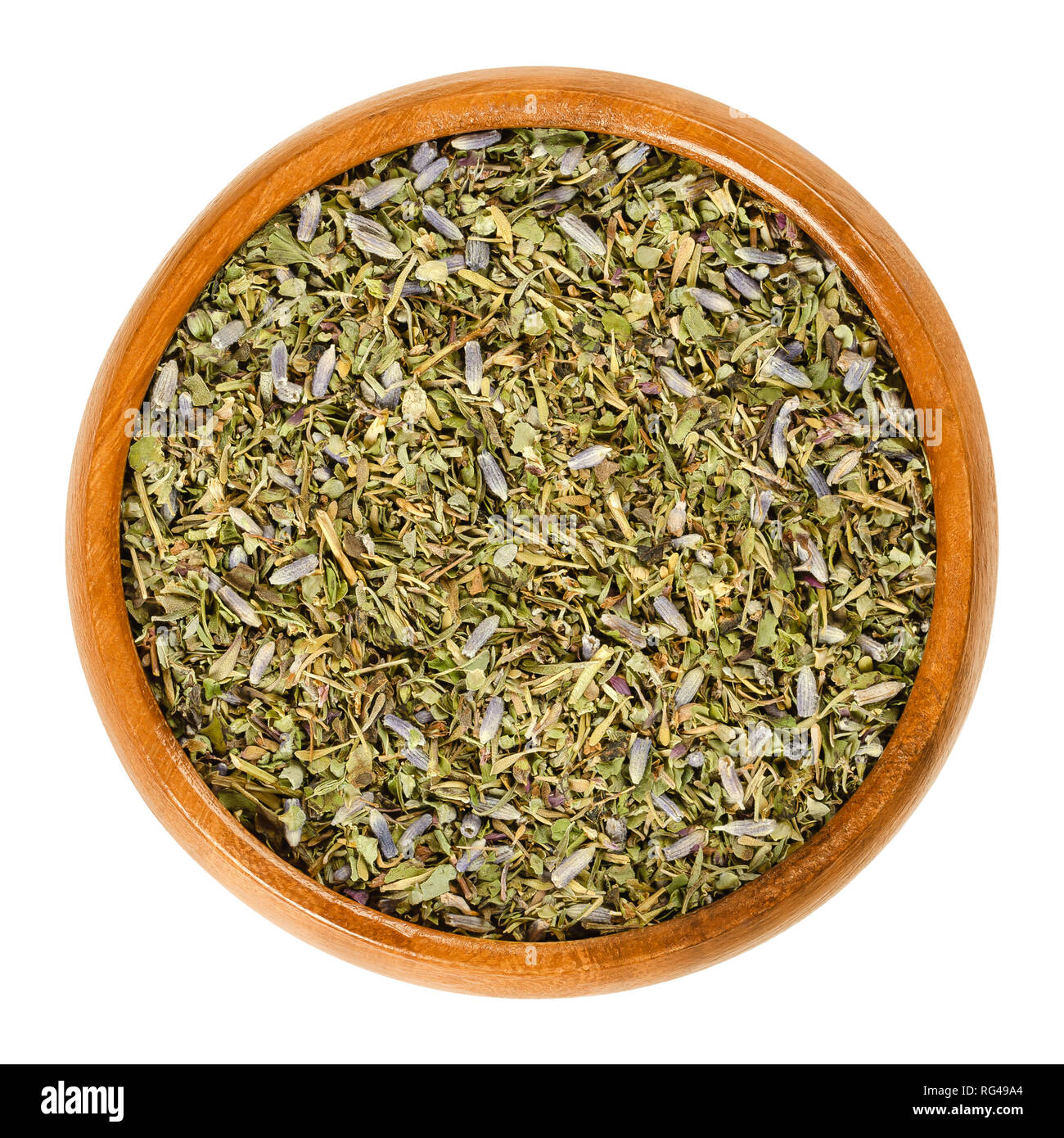 Herbes de Provence in wooden bowl. Mixture of dried herbs of the Provence, France. Savory, rosemary, thyme, lavender, oregano and marjoram. Stock Photo