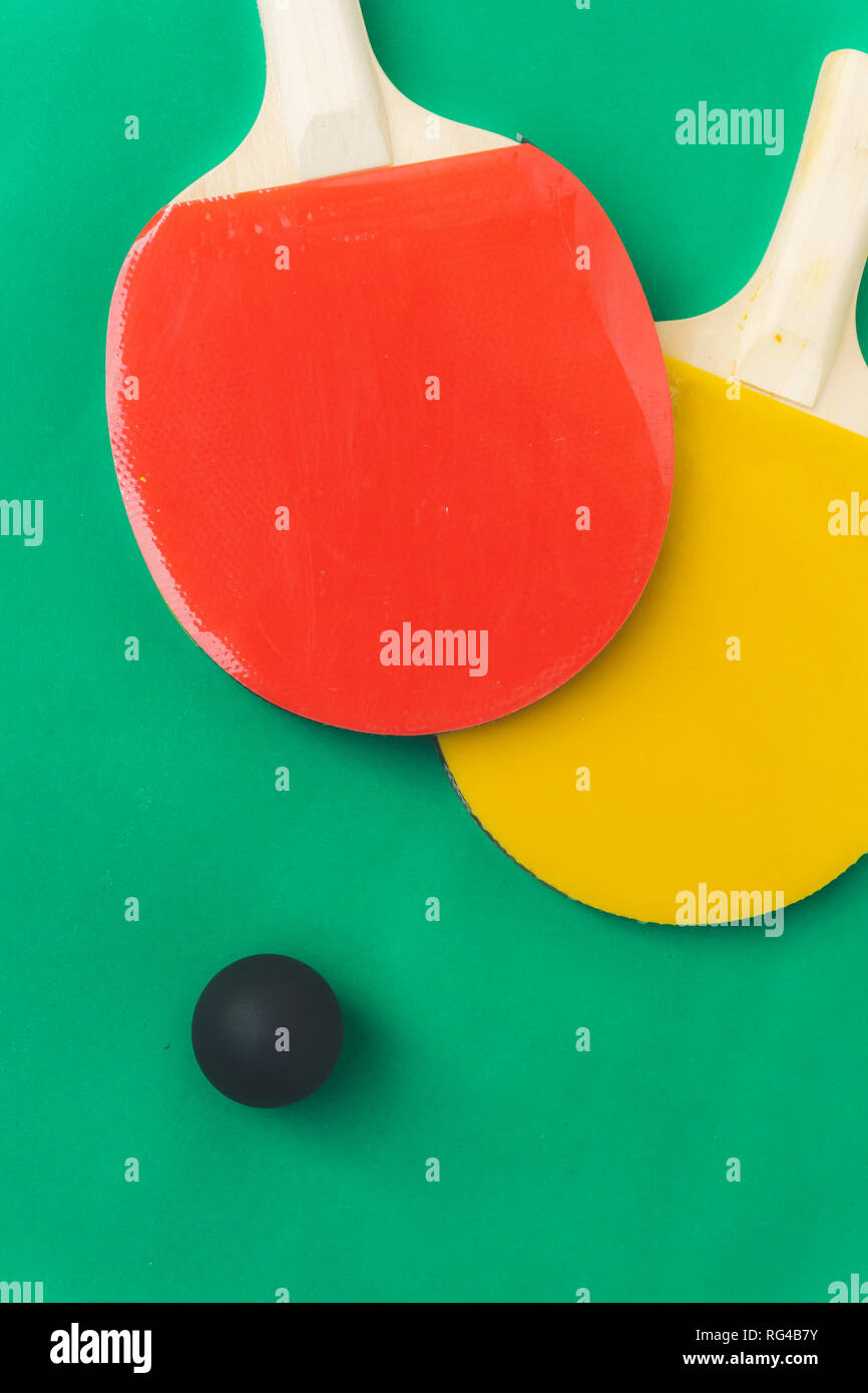 Red and yellow table tennis rackets with black balls, table tennis