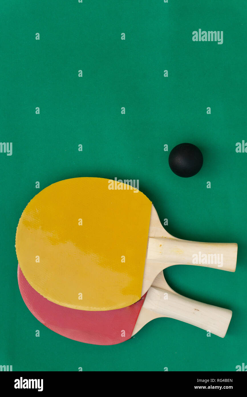 Red and yellow table tennis rackets with black balls, table tennis