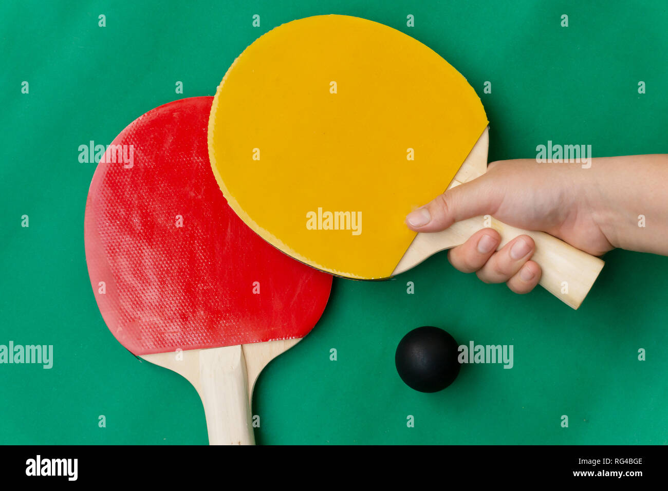 Red and yellow table tennis rackets with black balls, table tennis rackets and balls on table