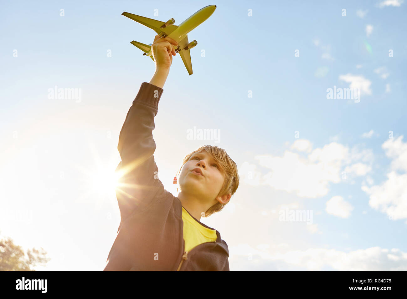 Boy while playing with airplane in hand in the summer in the garden ...