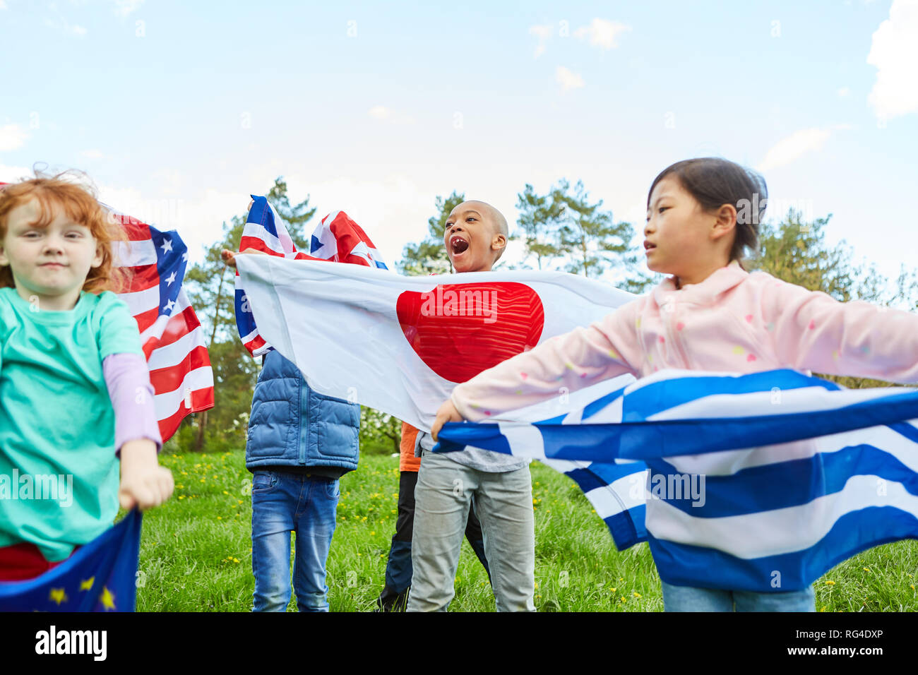 Children with national flags in the international youth camp as a symbol of cooperation Stock Photo