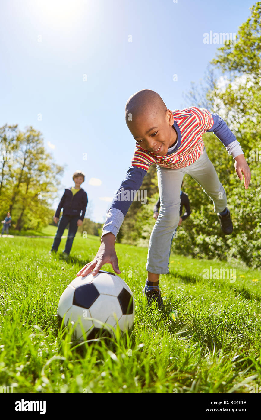 African boy lays down a football for a penalty on the meadow Stock Photo