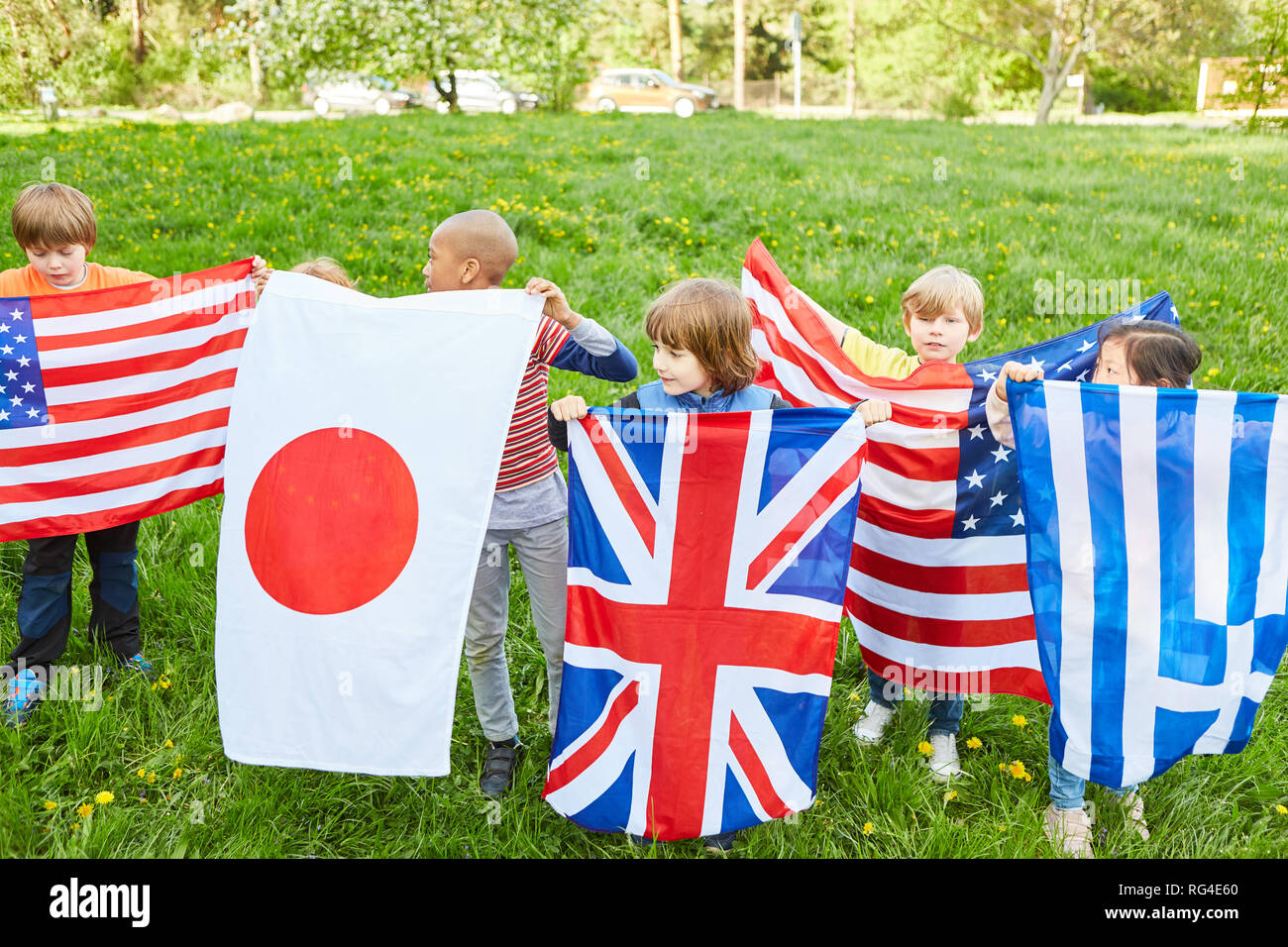 Children in the international summer camp hold flags as a symbol of international understanding Stock Photo