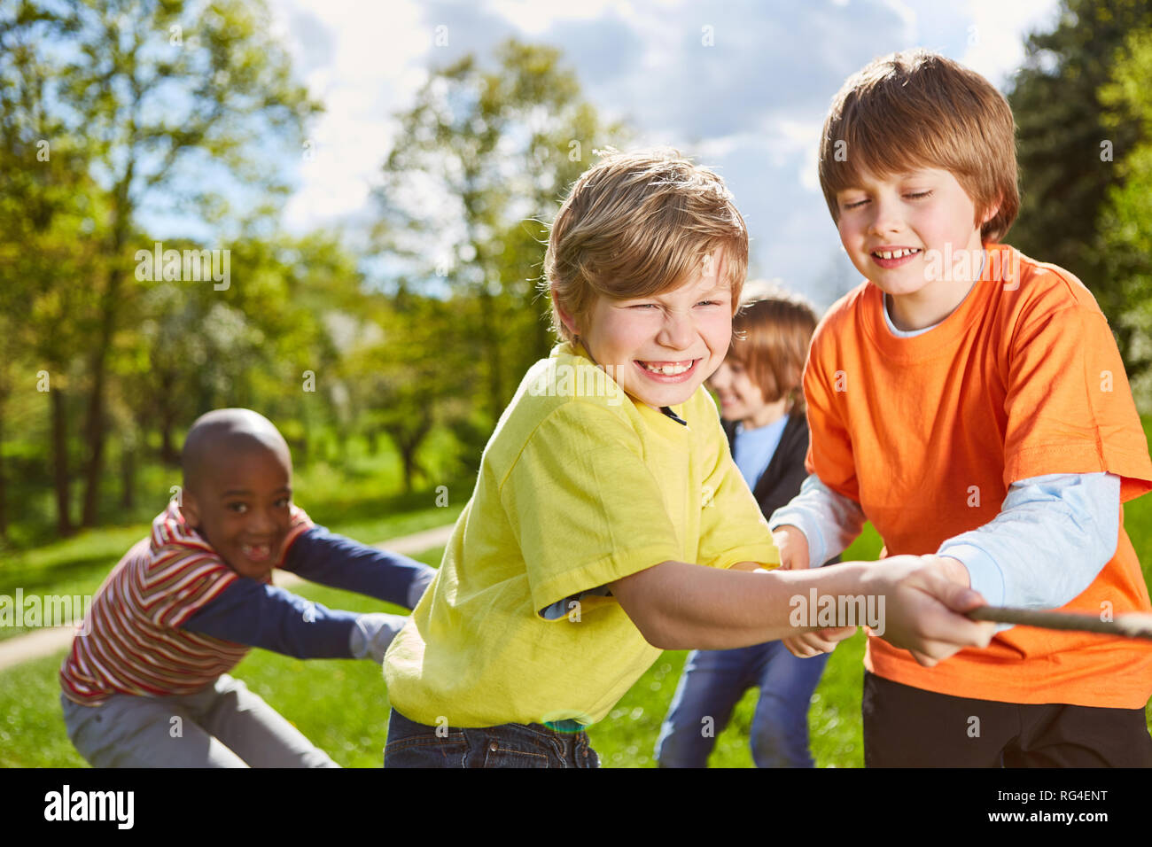 Multicultural kids team is having fun with tug-of-war competition in ...