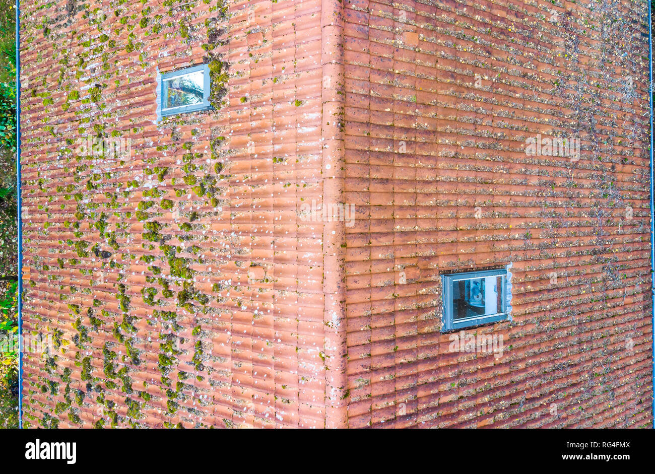 Inspection of the red tiled roof of a single-family house, inspection of the condition of the tiles on the roof of a detached house Stock Photo