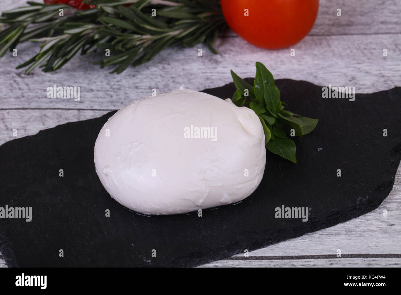 Italian Mozzarella cheese ball served basil and tomatoes Stock Photo