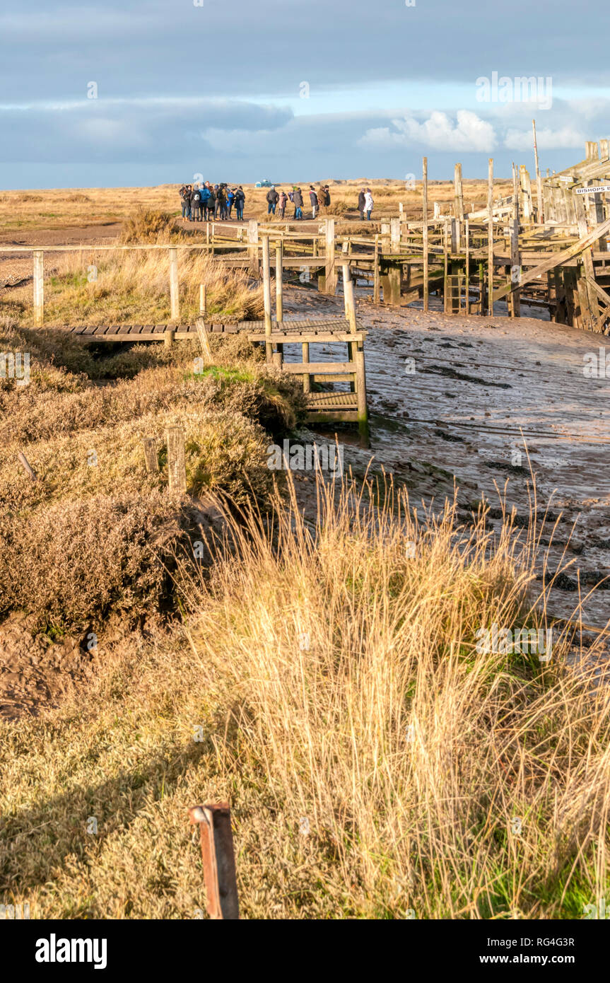 People waiting to board a boat for a seal watching trip at Morston Creek in the salt marshes on the North Norfolk coast. Stock Photo