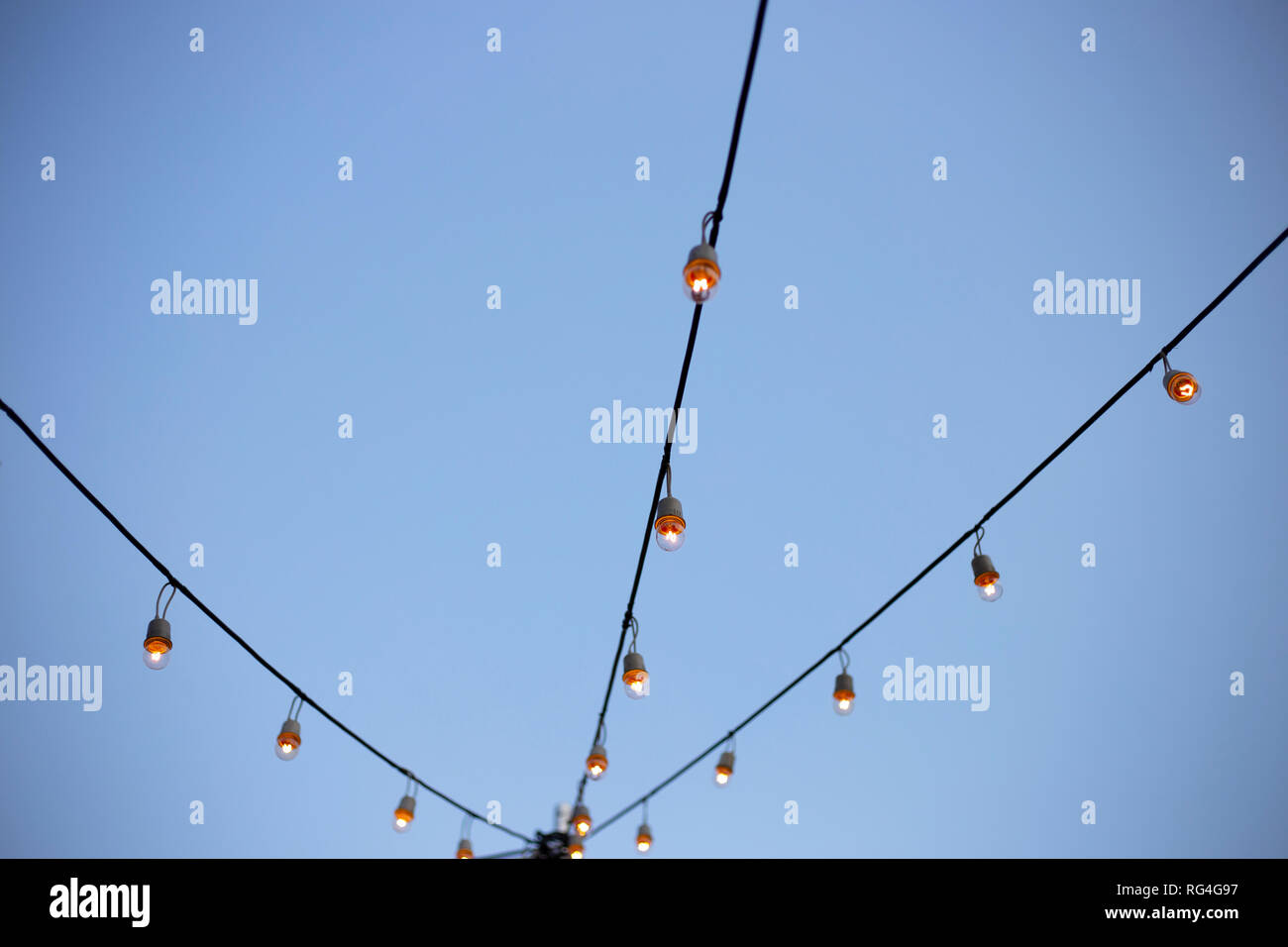 Light bulbs on string wire with sky Stock Photo
