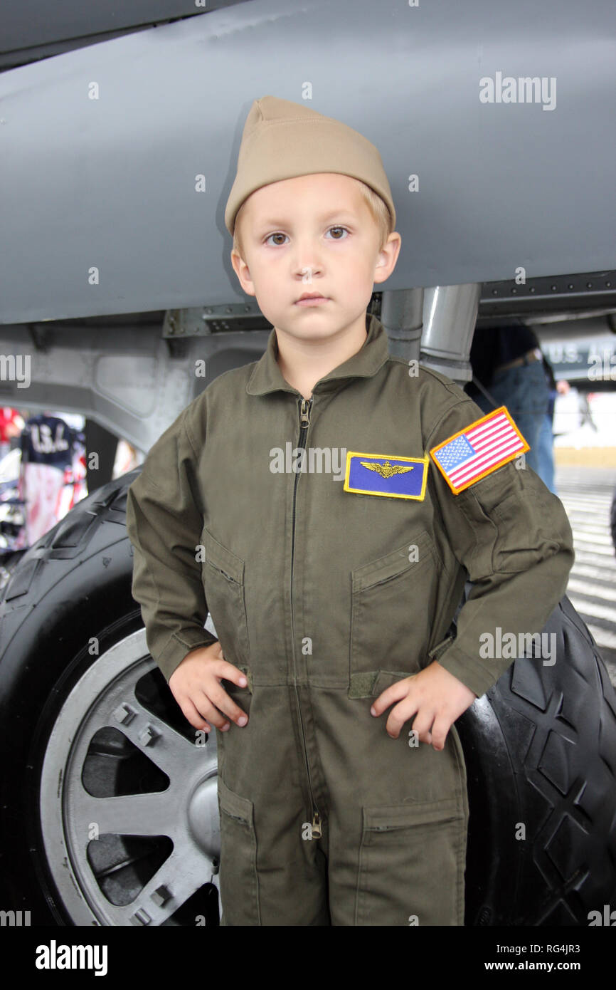 little boy pilot in flight suit in front of plane Stock Photo