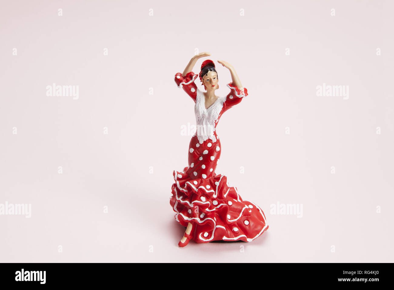 A Flamenco Dancer Figurine On A Pop Pink Background Minimal