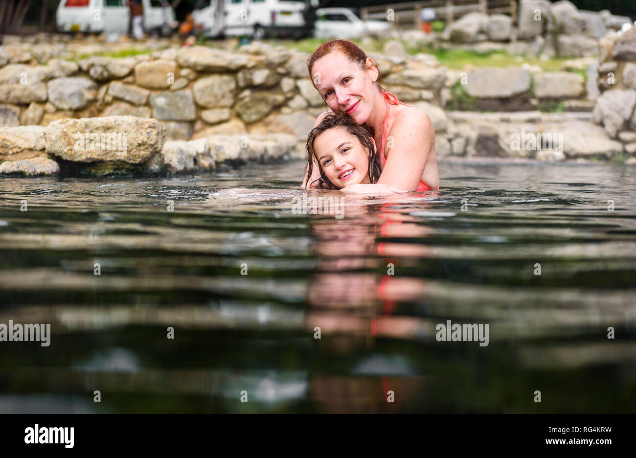 Mother and daughter relaxing in natural thermal water roman spa. Family retreat at outdoor pools and baths with hot, smoking thermal water and hot spr Stock Photo
