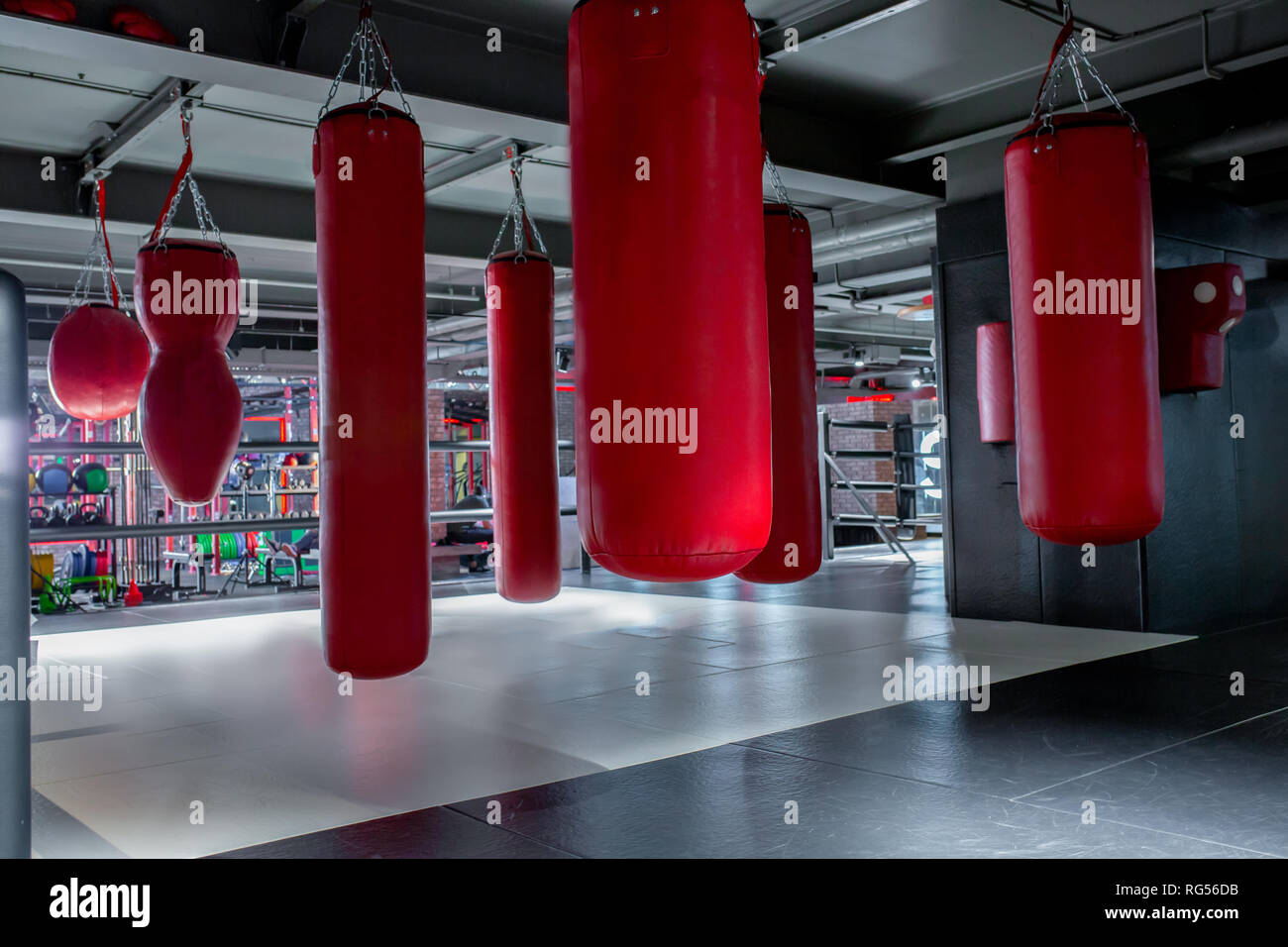 Red punching bags with gym background. Pears for boxing Stock Photo Alamy