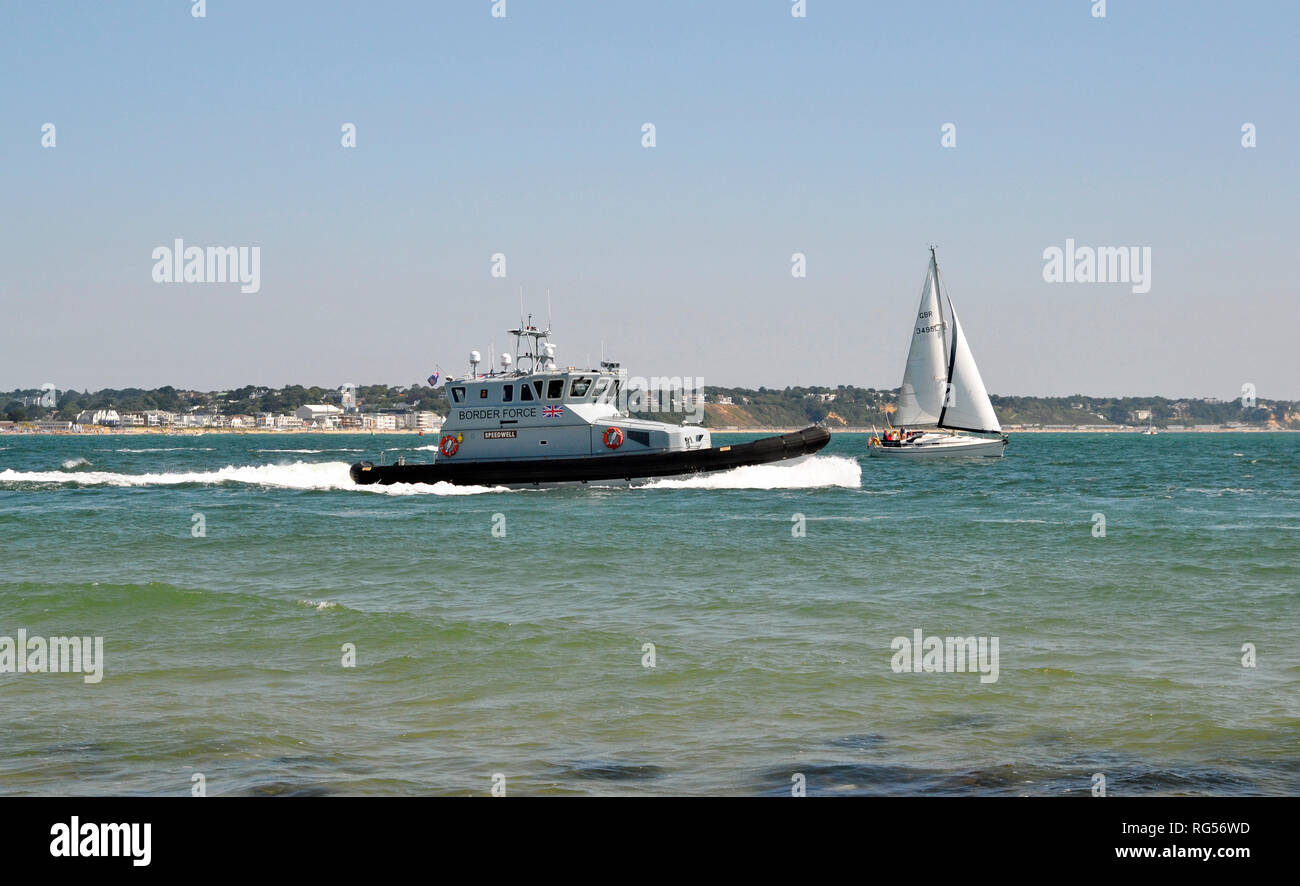 Border Force Patrol and a sail boat at Shell Bay, Swanage, Isle of Purbeck, Dorset, England, UK. View from the beach. Stock Photo