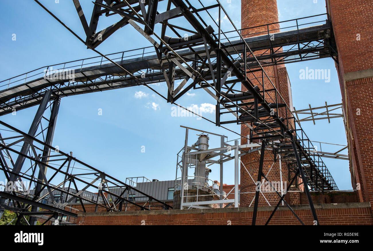 An industrial looking complex with a conveyor belt and smoke tower. Stock Photo