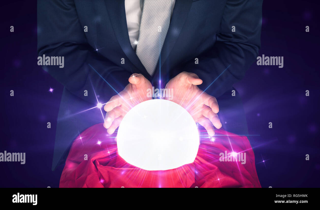 Young businessman sitting with crystal ball in action Stock Photo - Alamy