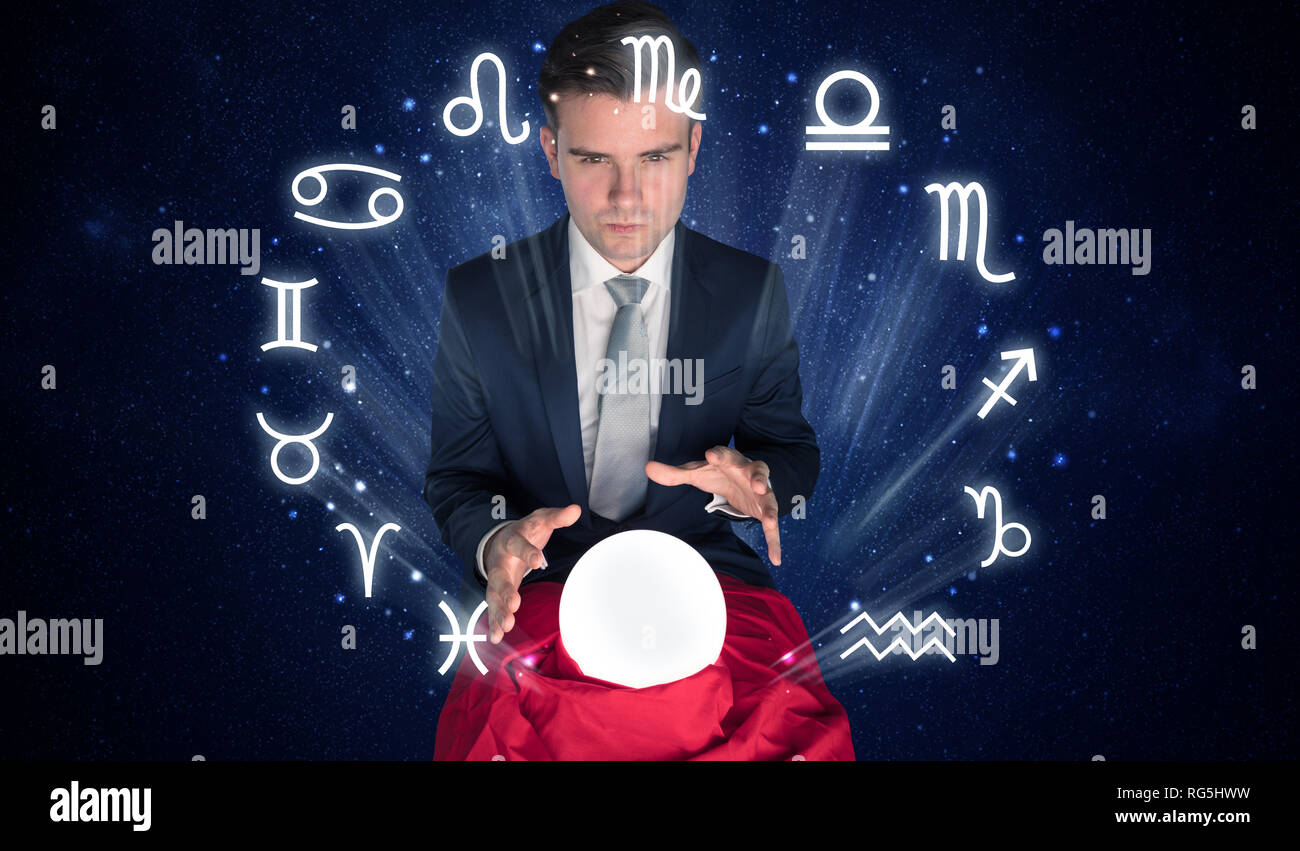 Young handsome astronaut looking for inspiration in his crystal magic ball  Stock Photo