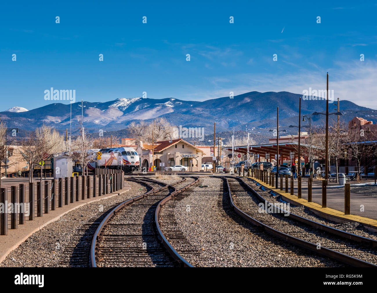 Santa Fe train depot, rail runner train, railroad tracks and Sangre de Cristo Mountains with snow in Santa Fe, New Mexico Railyard. Stock Photo