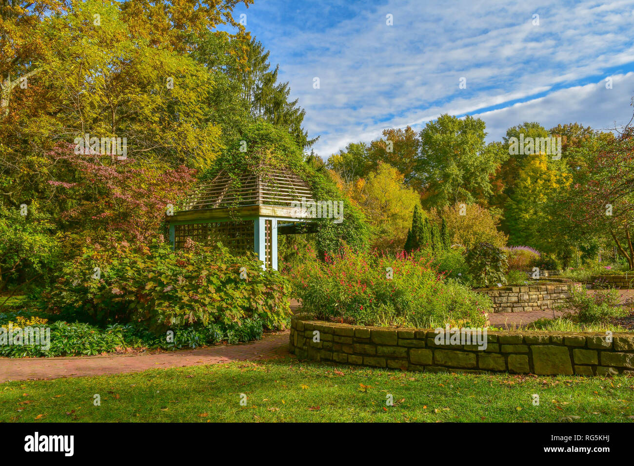 A gazebo cast in the fall morning light. A stone path leads up to the ...
