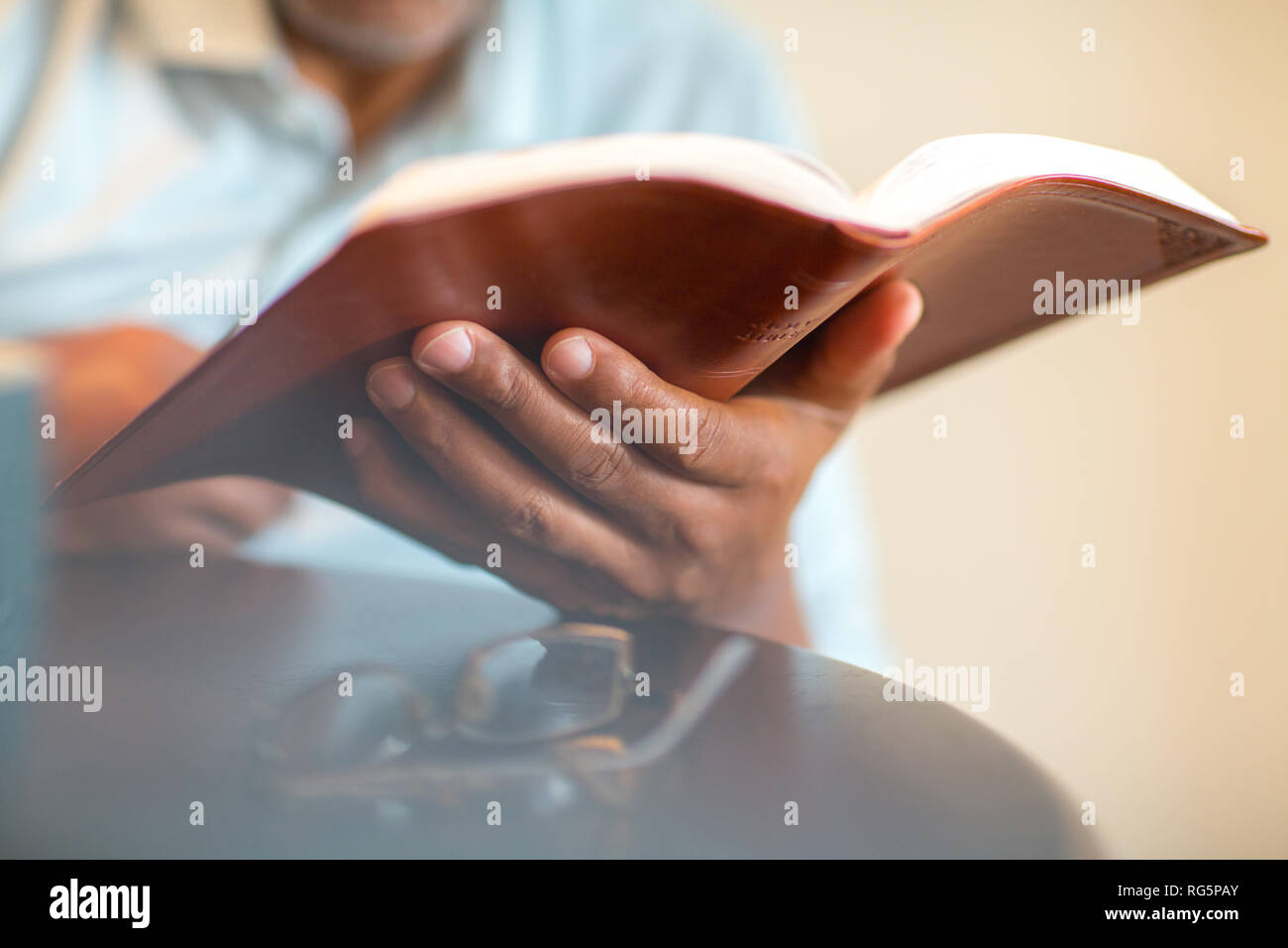 African American man praying and reading the Bible. Stock Photo