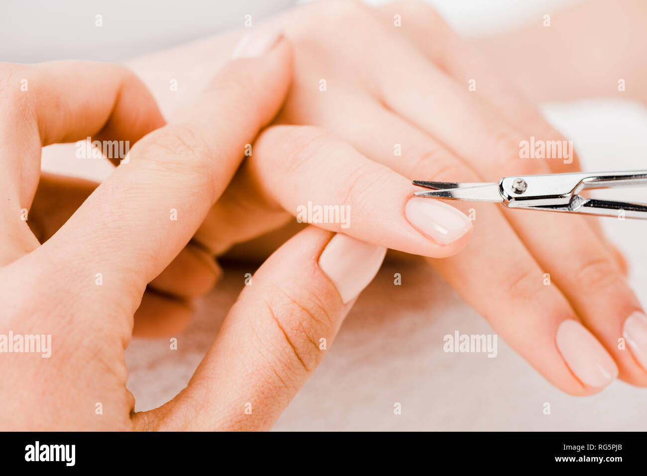 Cropped view of manicurist using manicure scissors to remove cuticle Stock Photo