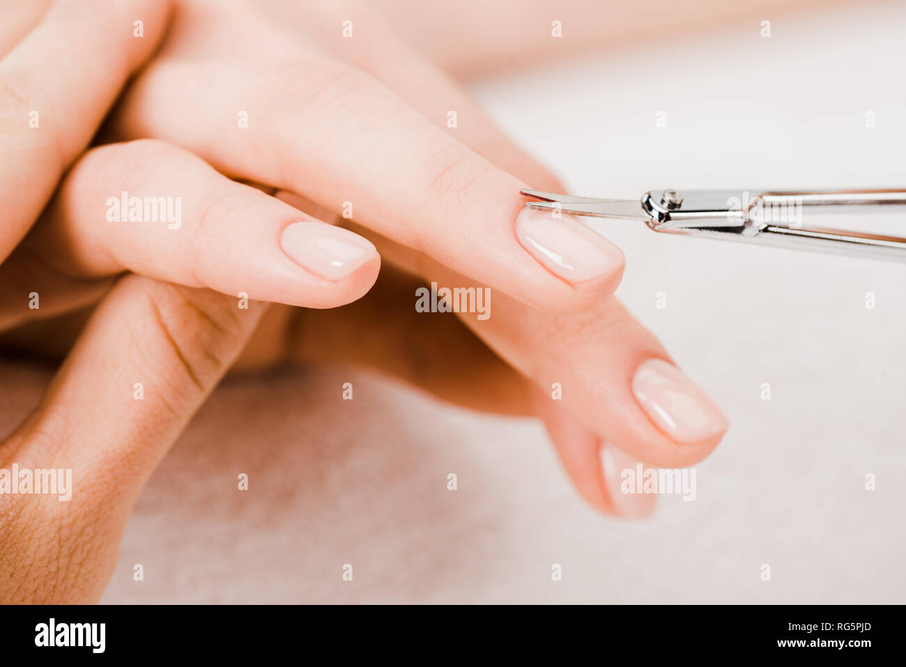 Cropped view of manicurist using manicure scissors to remove cuticle Stock Photo