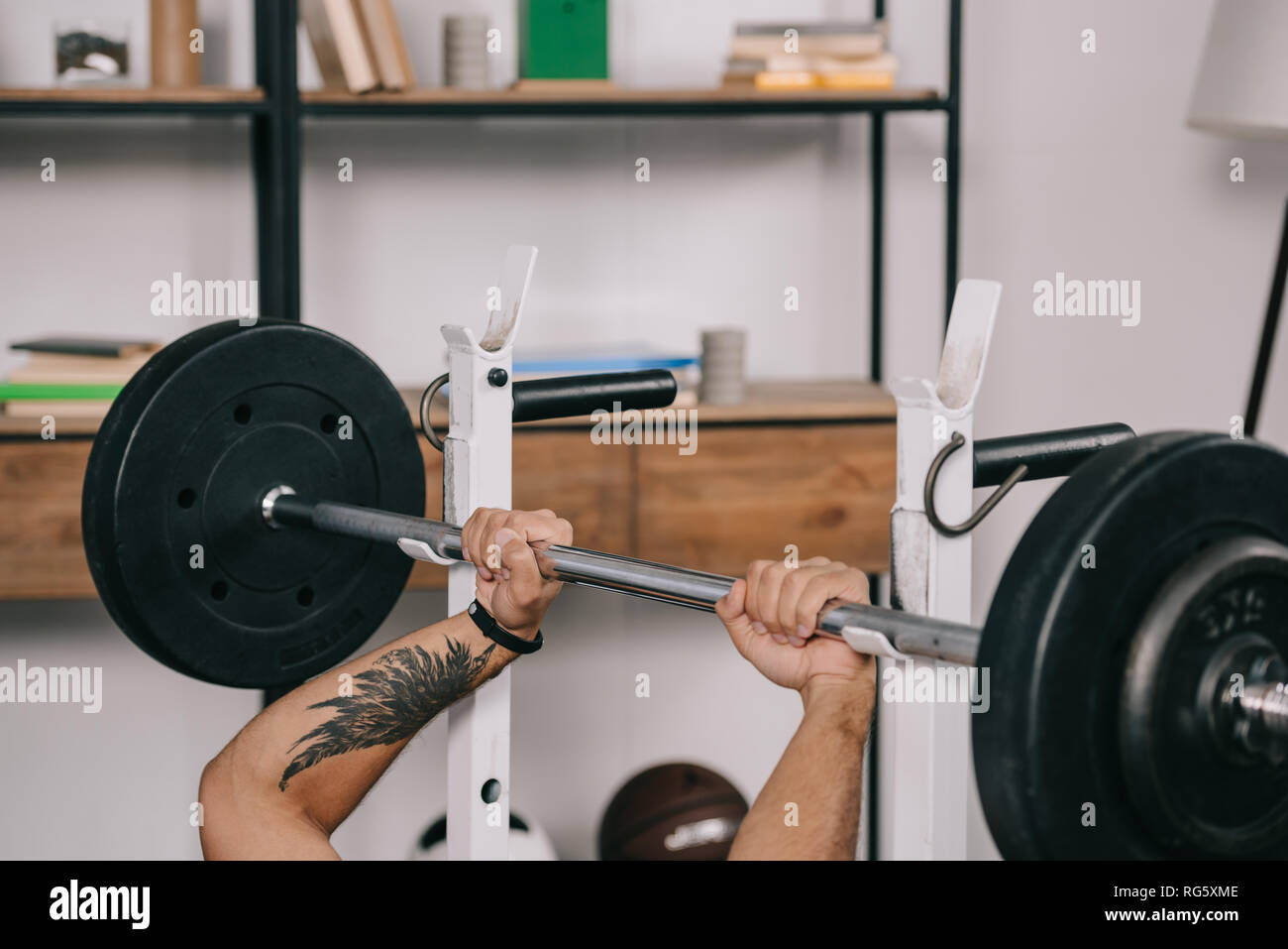 cropped view of man with tattoo workout with barbell in home gym Stock  Photo - Alamy