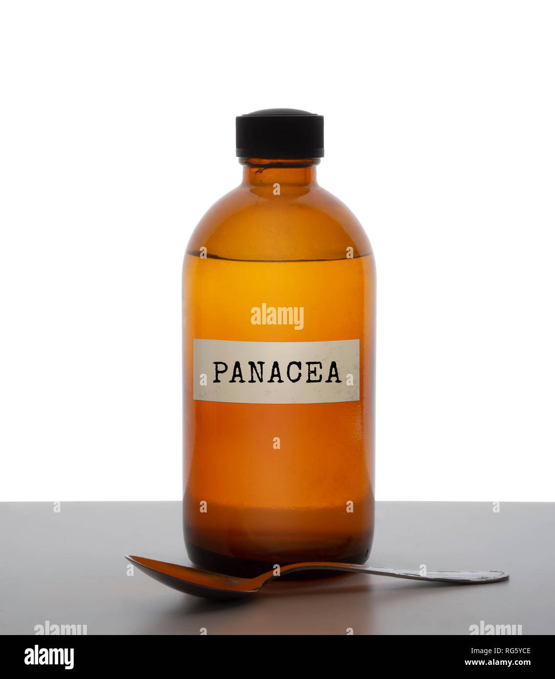 Panacea, magic potion. Old brown glass medicine bottle with spoon, label. Pharmaceutical concept or ironic metaphor, wishful thinking. White behind. Stock Photo