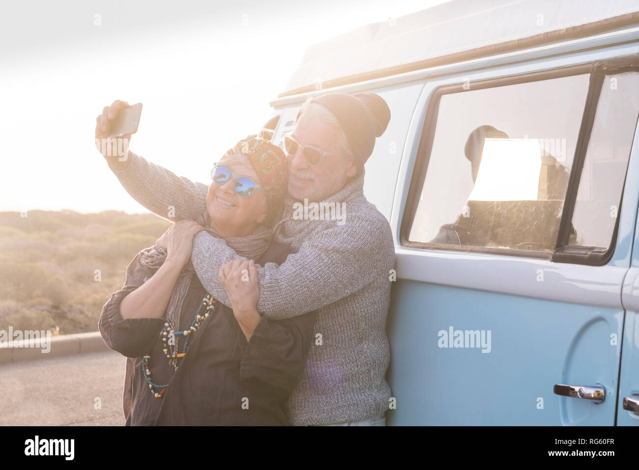 Happy old senior adult couple enjoy and have fun together with love in vacation and outdoor leisure activity using modern smart ph0ne to take picture  Stock Photo
