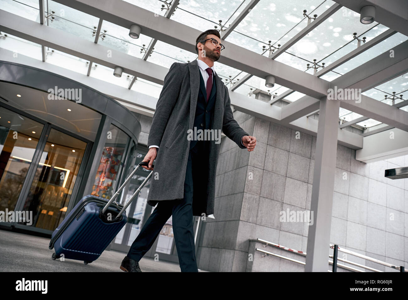 Young businessman after arriving. Comfortable airport, work trip, business  lifestyle. African-american male model with luggage after coming to end  point of his trip. Leaving terminal with documents Stock Photo - Alamy