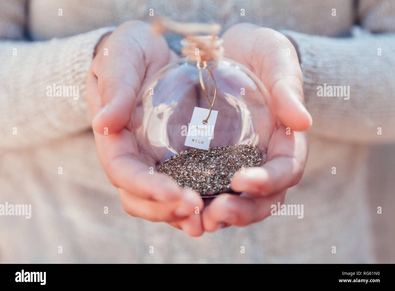 Girl holding a glass bauble with a make a wish message Stock Photo