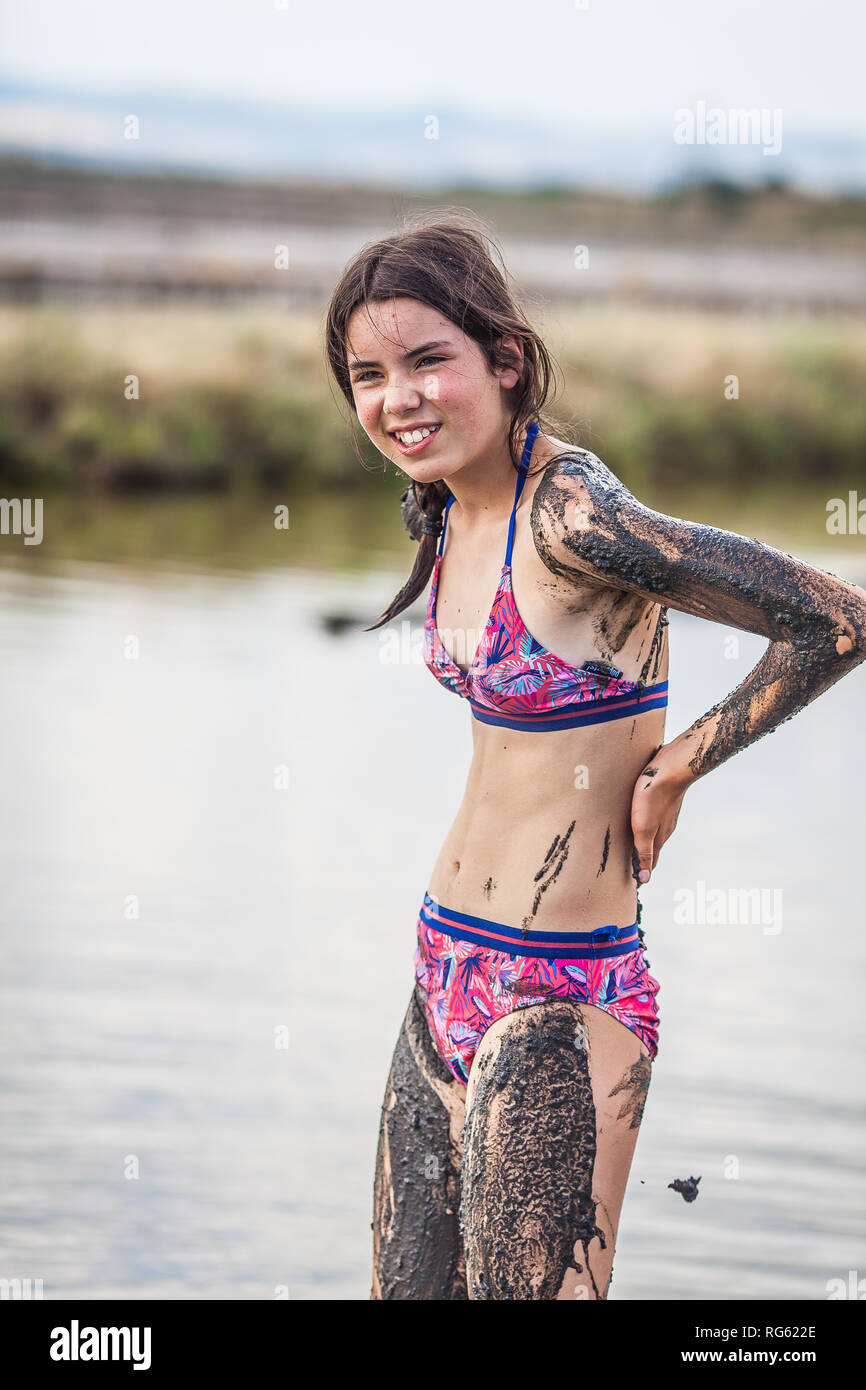 Girl standing in Atanasovsko Lake covering herself in mud, Burgas, Bulgaria  Stock Photo - Alamy, image size:866x1390