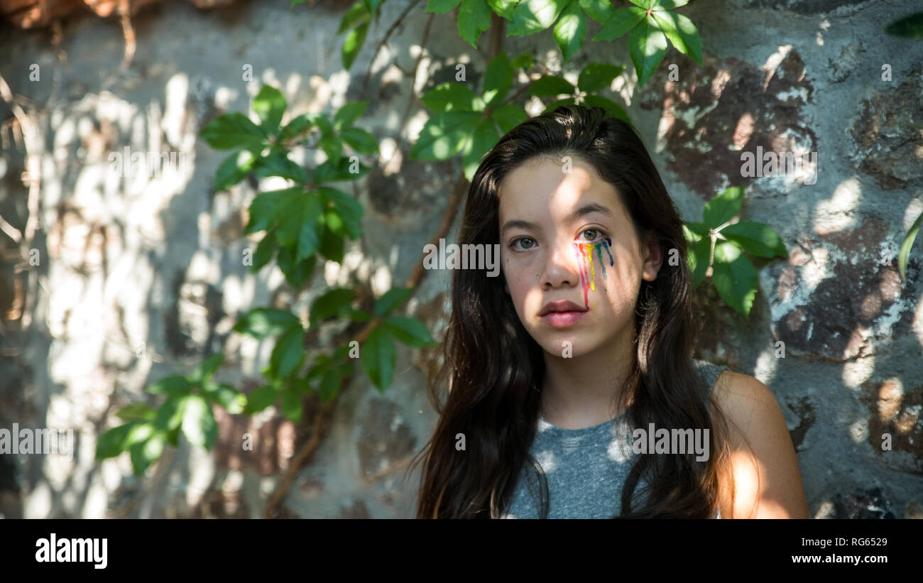 Young teen with colorful tear drops painted on her face Stock Photo