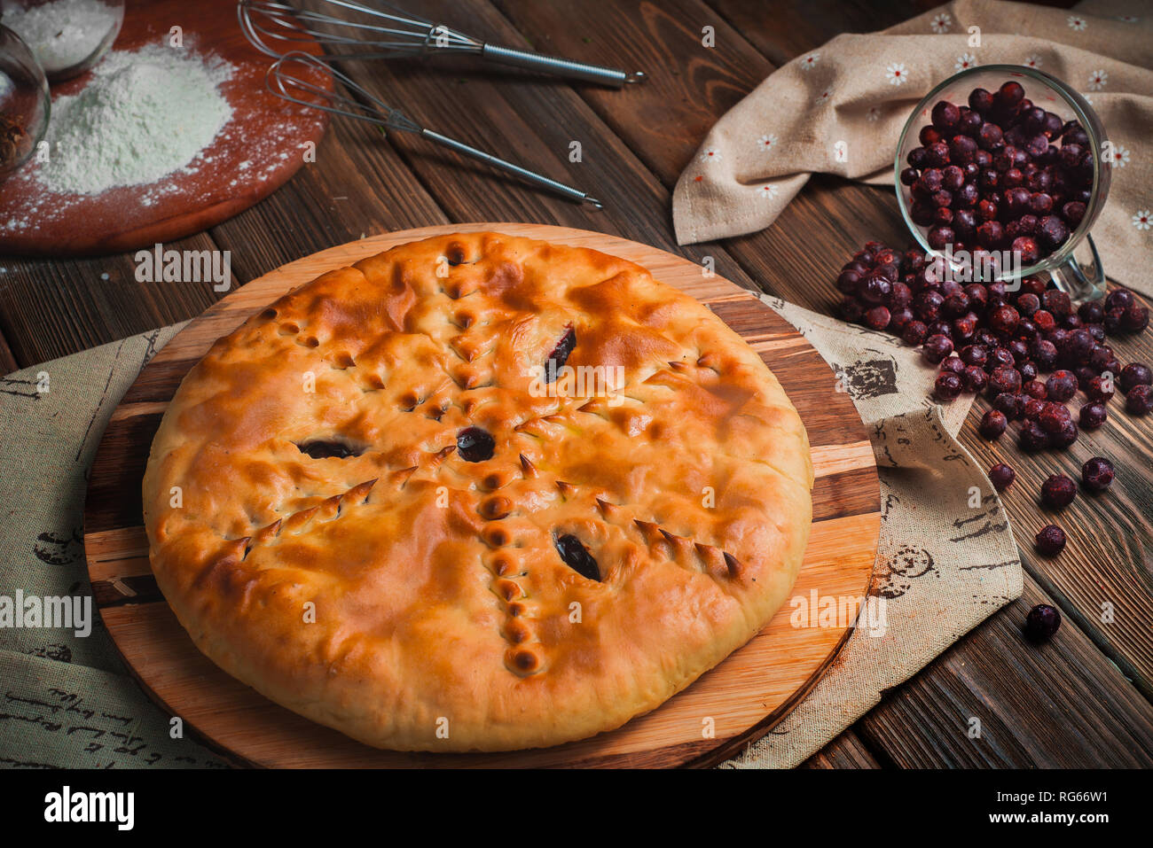 Homemade currant pie on a wooden kitchen table with ingredients