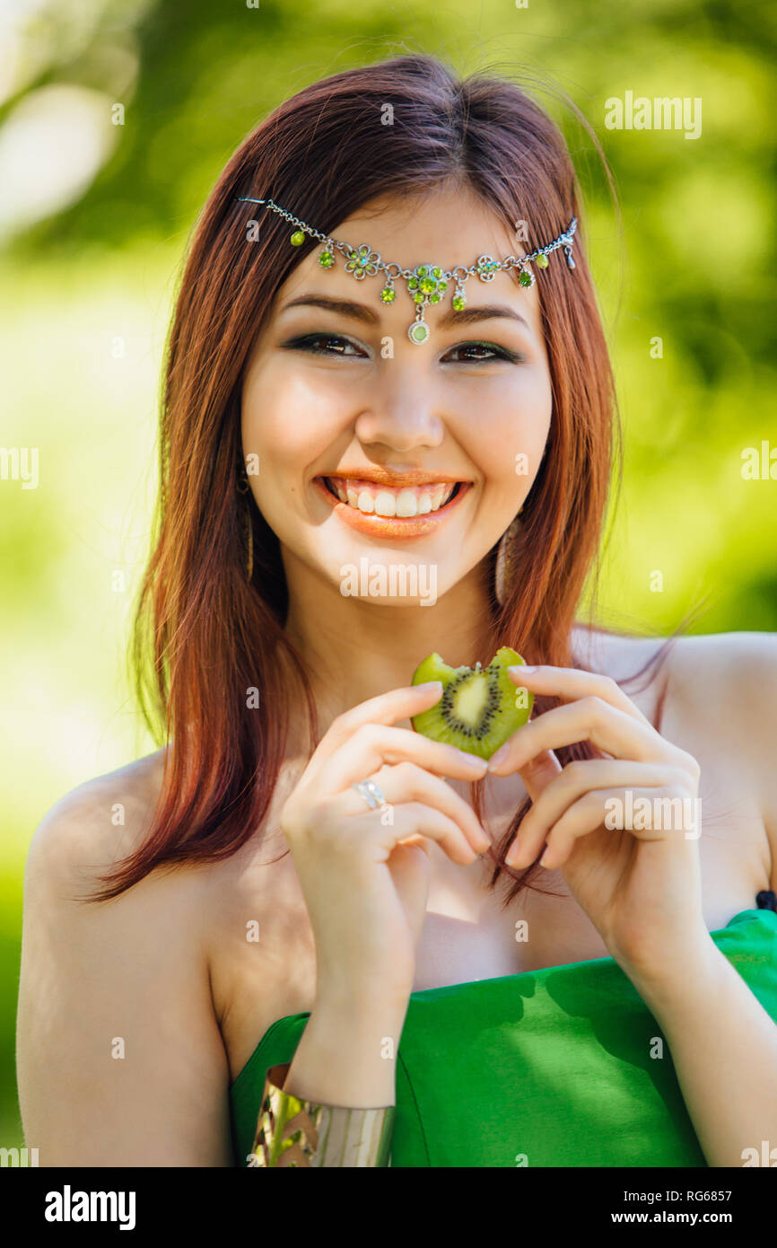 Portrait of a beautiful young asian woman in green dress and diadema on ...