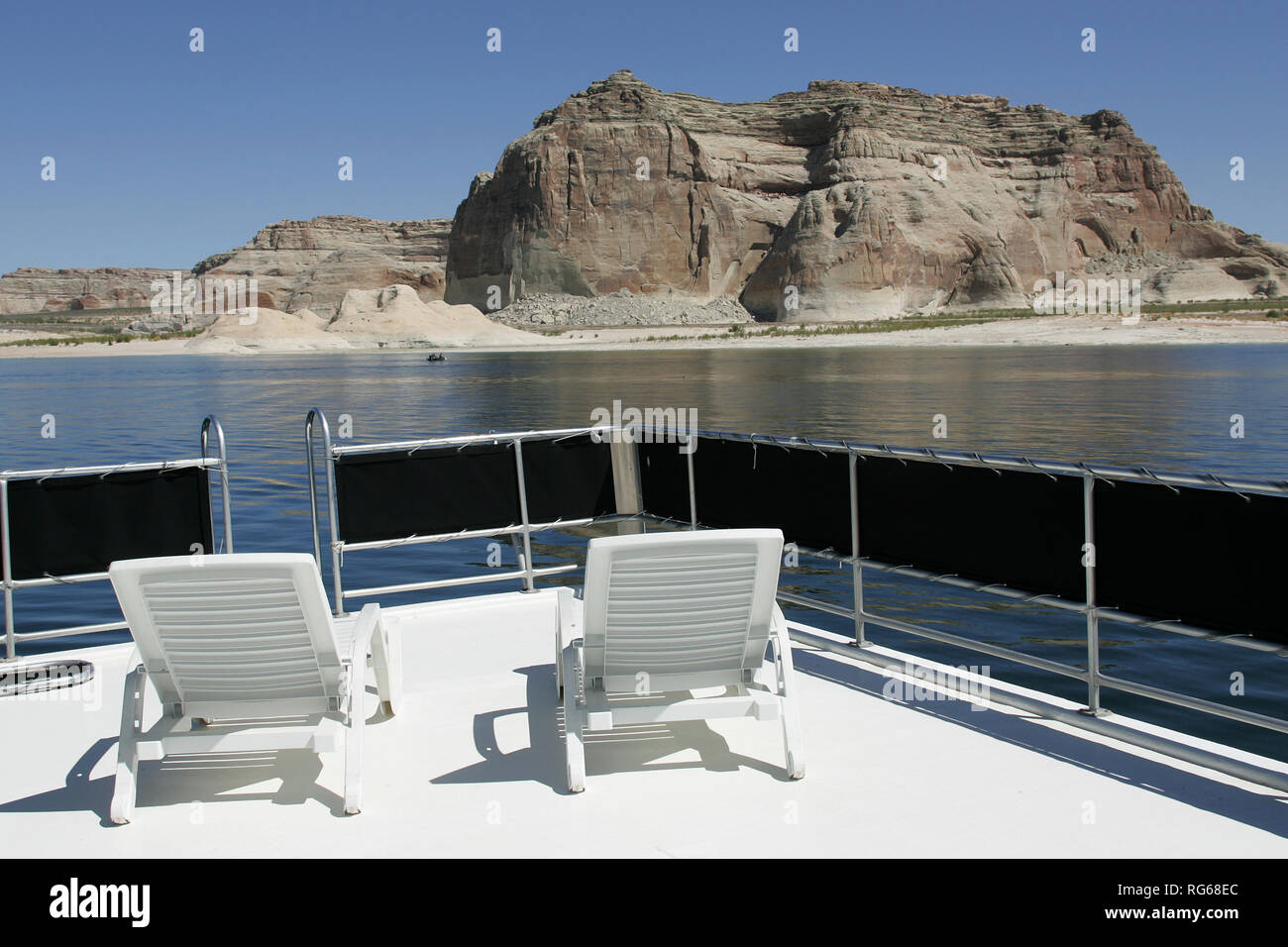 Two Chairs On A Patio On Top Of A Houseboat Sitting At Lake Powell