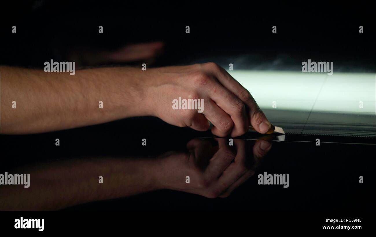 The protective film is removed from the machine with a paper knife. Car