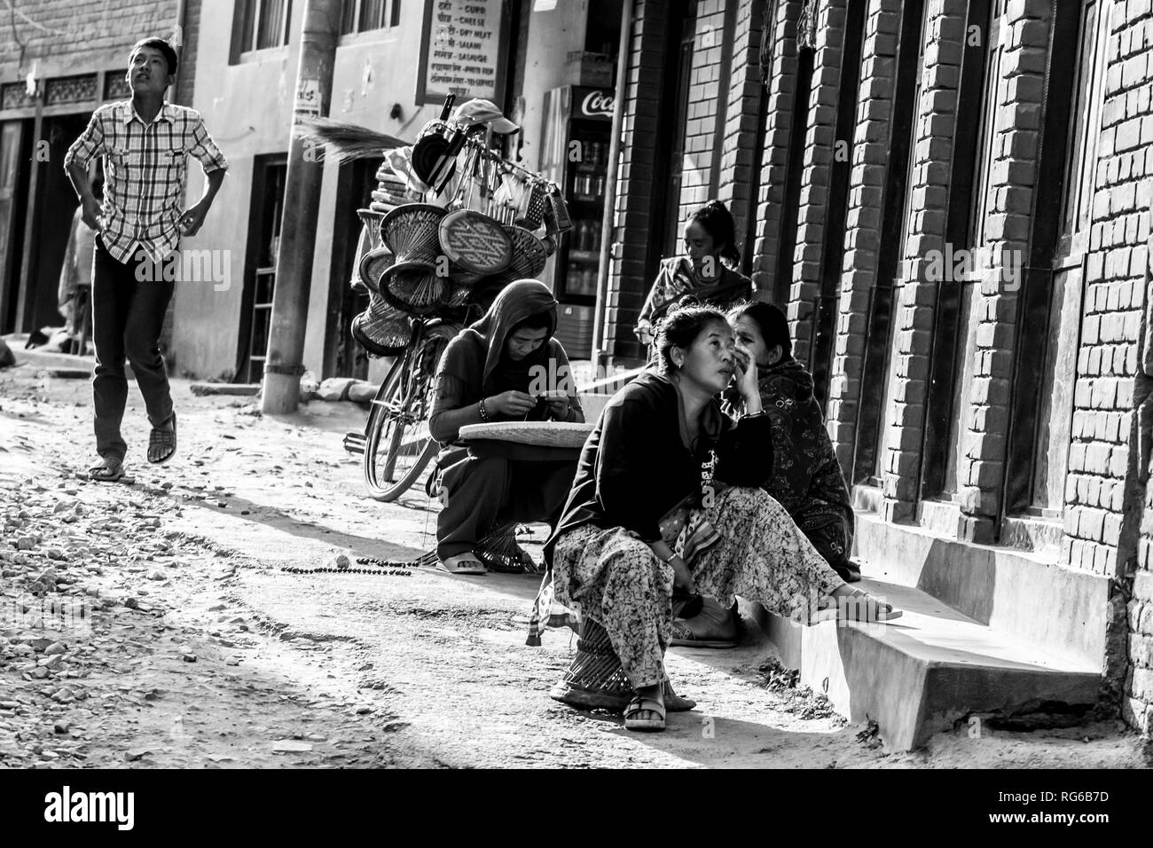 Kathmandu, Nepal - November 5, 2015: Nepalese people sitting along a street in central Kathmandu. Stock Photo