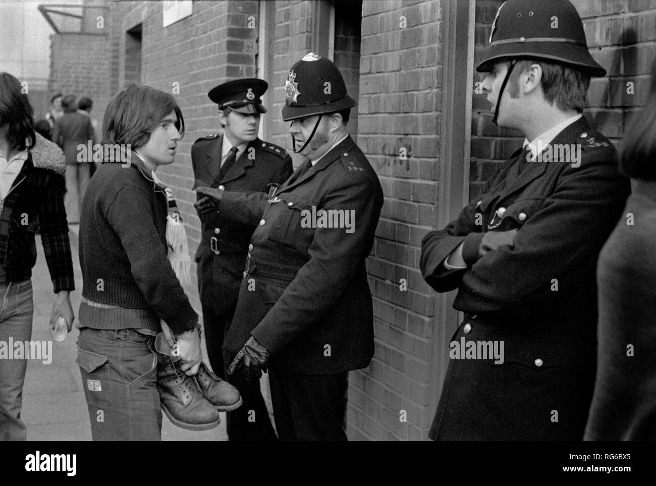 Football fans 1970s UK. Manchester City football fan prevented from entering Queens Park Rangers QPR football ground because he is wearing metal toed working boots. Police said he had to take them off and then was allowed into the football stadium. 1972 UK HOMER SYKES Stock Photo
