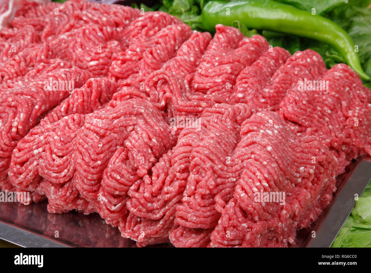 Uncooked ground beef steak and green pepper Stock Photo