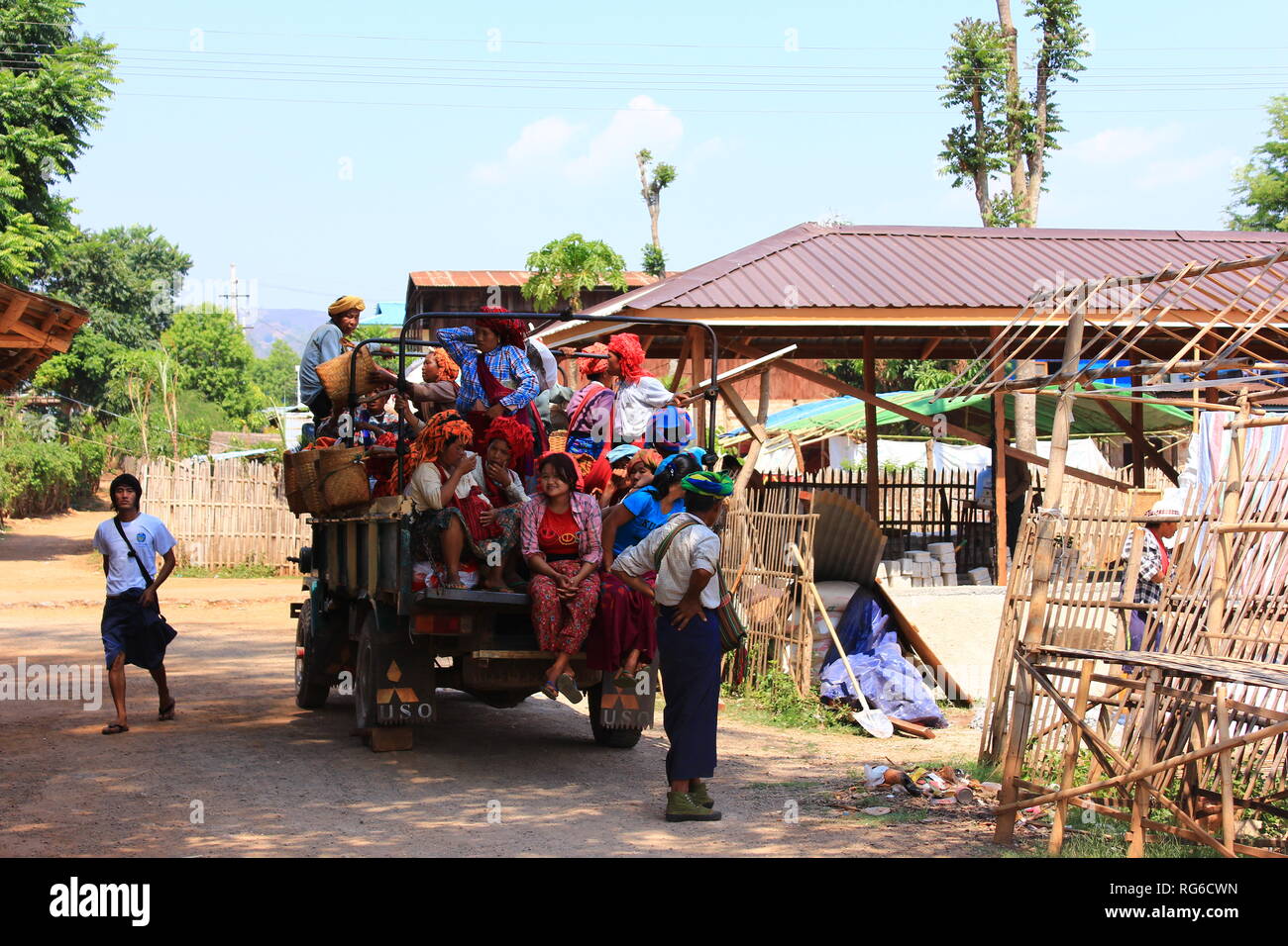 Numerous women sitting gathered together on a truck on their way to work in Inle Lake in Myanmar Stock Photo