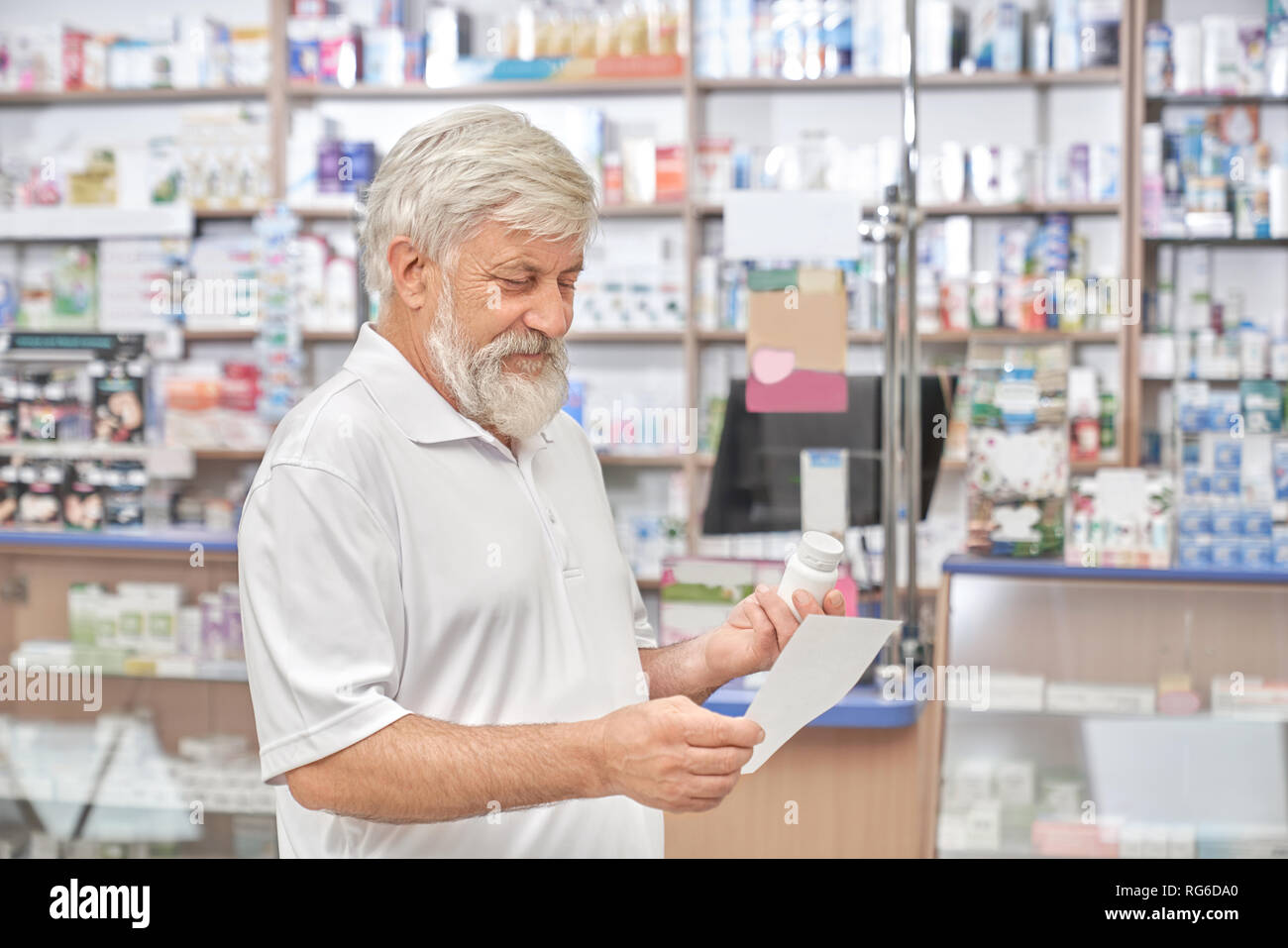 Cheerful Old Man Standing In Drugstore And Looking At Prescription
