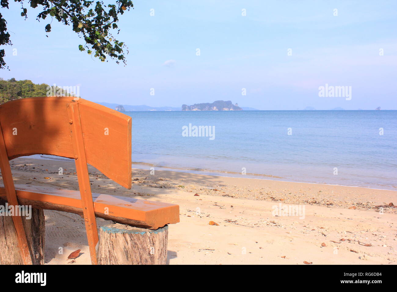 Holzbank am Strand einer thailändischen Insel mit Ausblick aufs Meer und die umgebenden Inseln Stock Photo