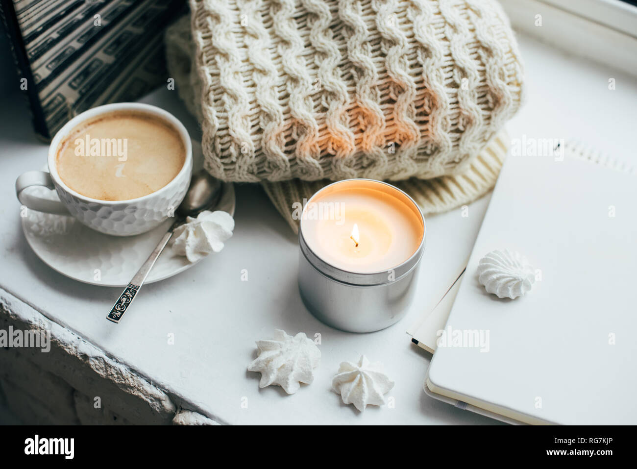 Cozy winter home interior with knitted blanket and candle Stock Photo