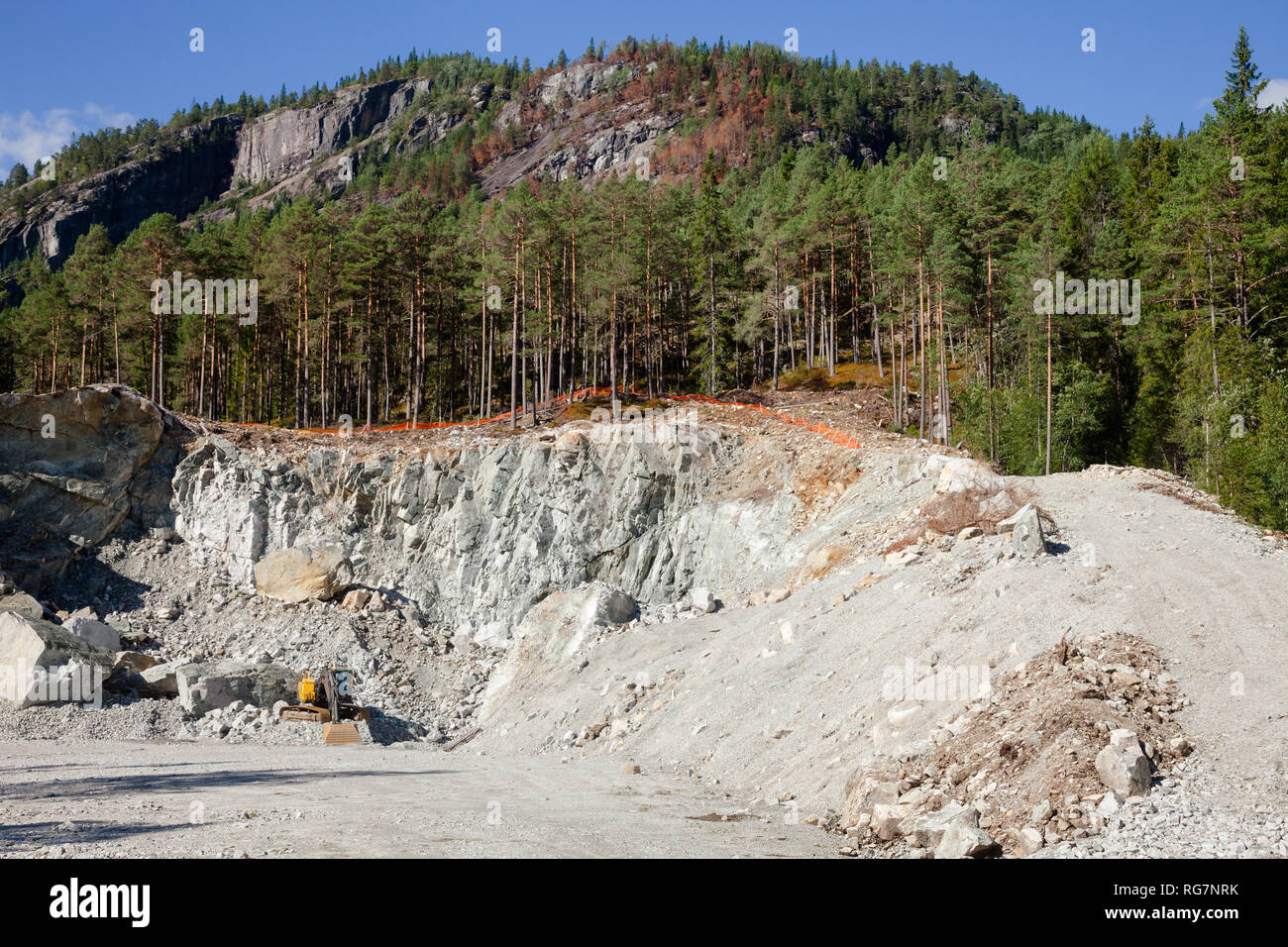 Excavator at small quarry in Norway, Scandinavia, mining construction aggregate and riprap Stock Photo