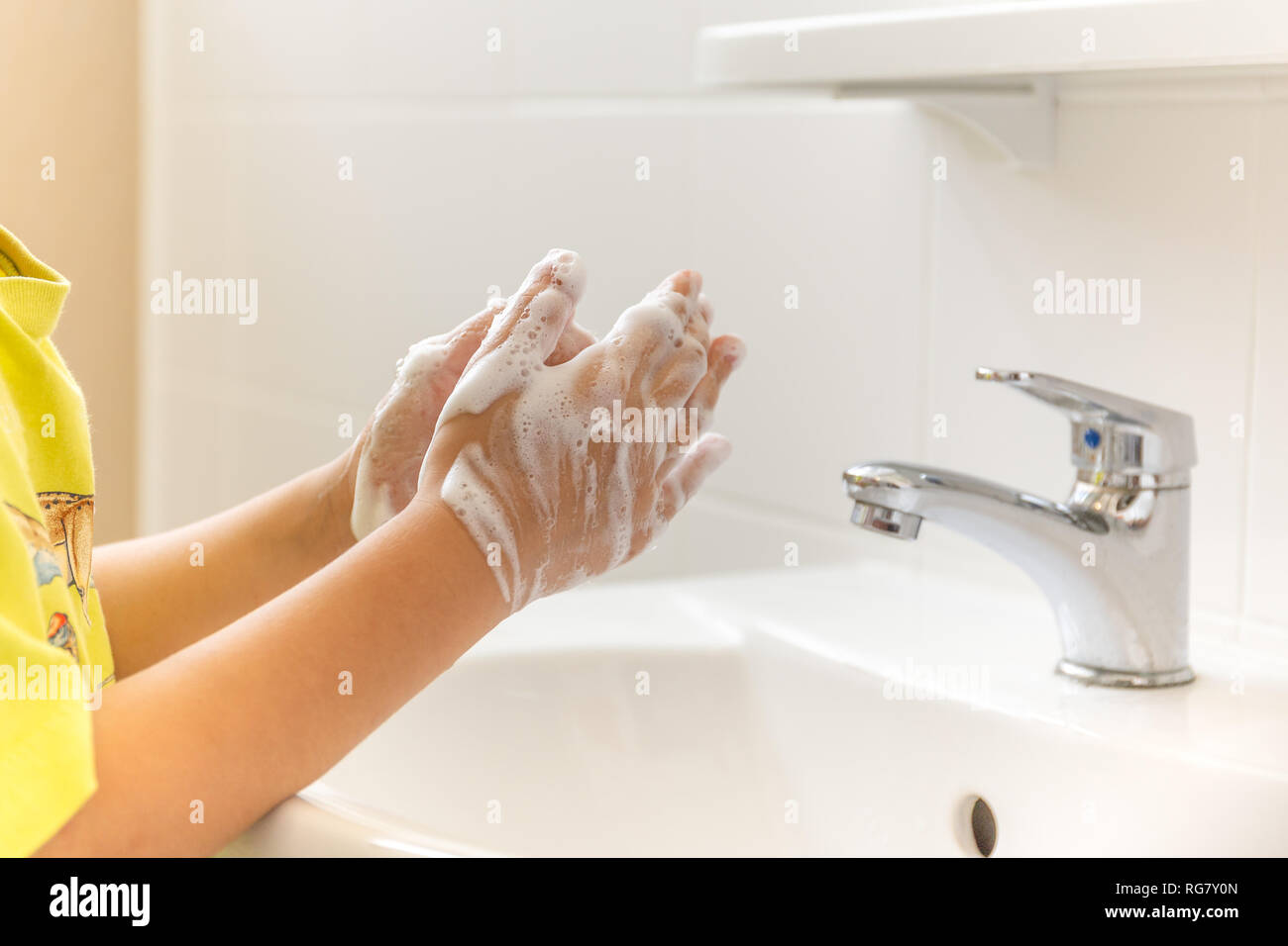 Children with soapy hands washed in bathroom sink. Stock Photo