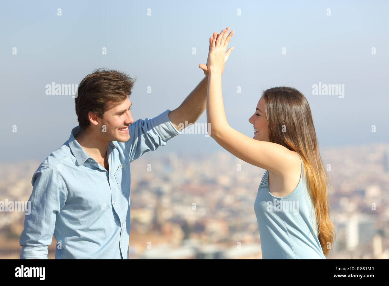 Happy friends giving high five outdoors in a city outskirts Stock Photo ...