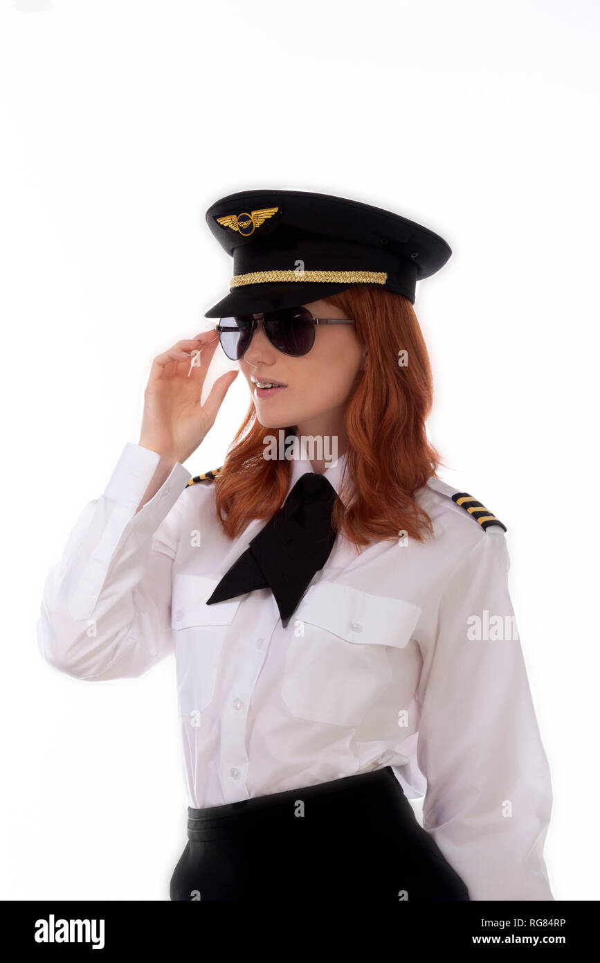 Young female pilot with red hair standing in airline uniform including a  hat Stock Photo - Alamy