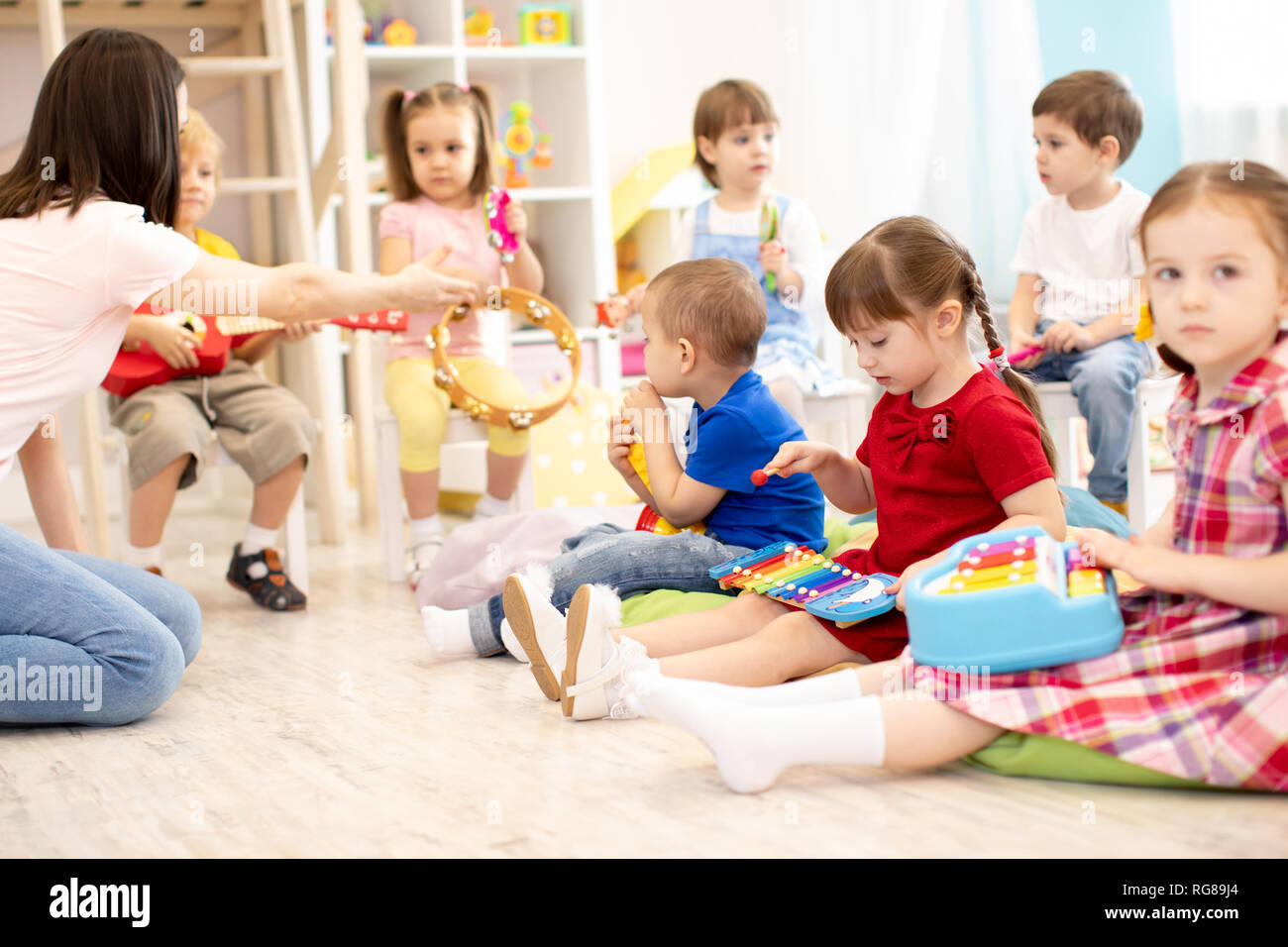 Teacher and cute children during music lesson in preschool Stock Photo