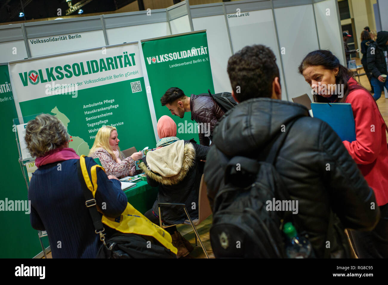 Berlin, Germany. 28th Jan, 2019. At the job exchange for refugees and foreign job seekers at the Estrel Hotel, visitors talk to an employee at an application stand of Volkssolidarität. The fair is organised by the Federal Employment Agency and the Estrel Hotel and is intended to make it easier for immigrants with prospects of staying in Germany to find jobs and training places. Credit: Gregor Fischer/dpa/Alamy Live News Stock Photo